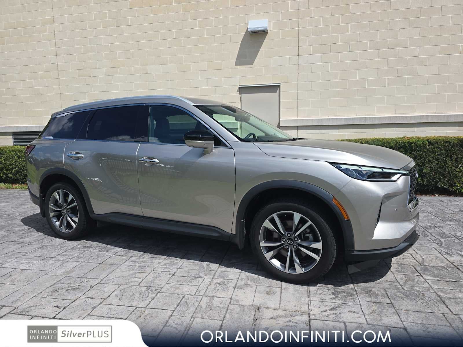 2023 INFINITI QX60 LUXE in Warm Titanium — front three-quarter view